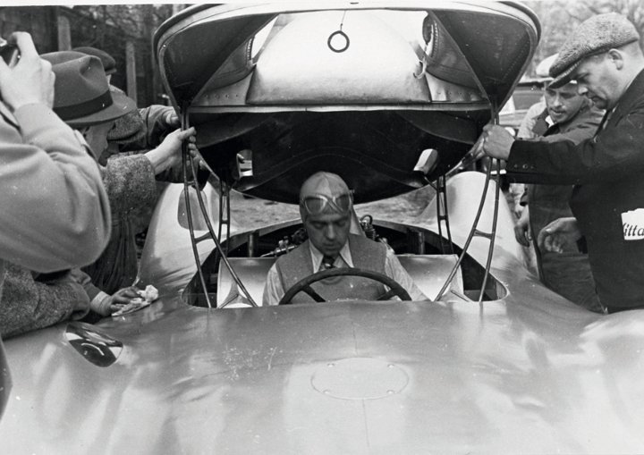 Bernd Rosemeyer mit Weste und Krawatte bei einem Test auf der Berliner Avus im April 1937